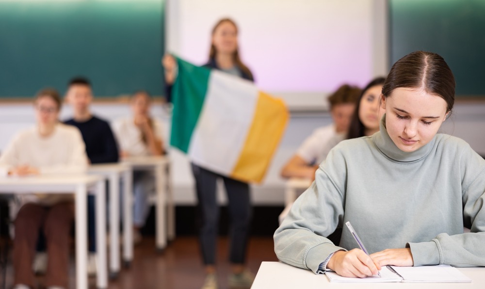 profesora desenfocada en clase sostiene bandera de irlanda